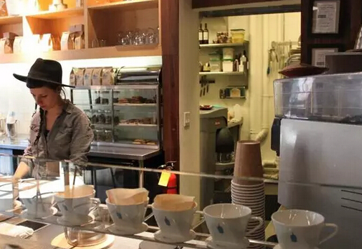 在柜台的后面，服务员管理可调制 7杯咖啡的滴管。